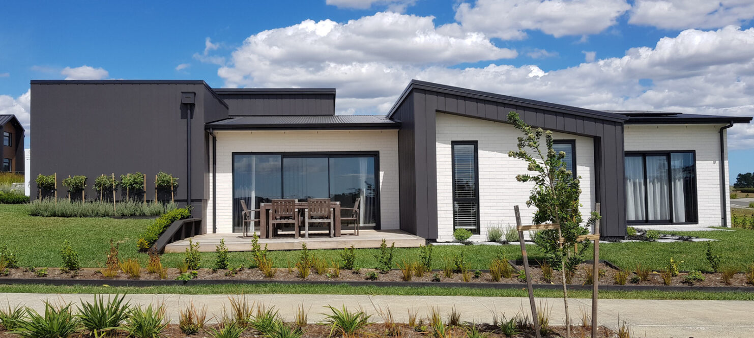 black house with deck and chairs of new build home at paerata rise