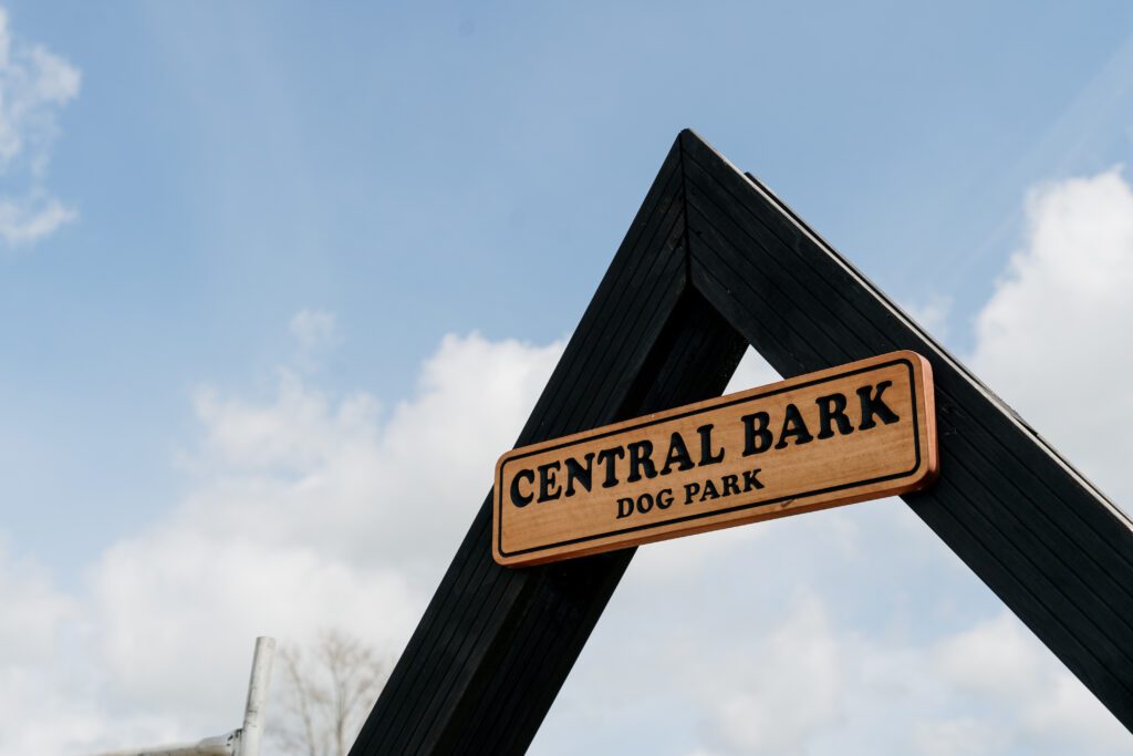 A wooden sign of central bark dog park at Paerata Rise
